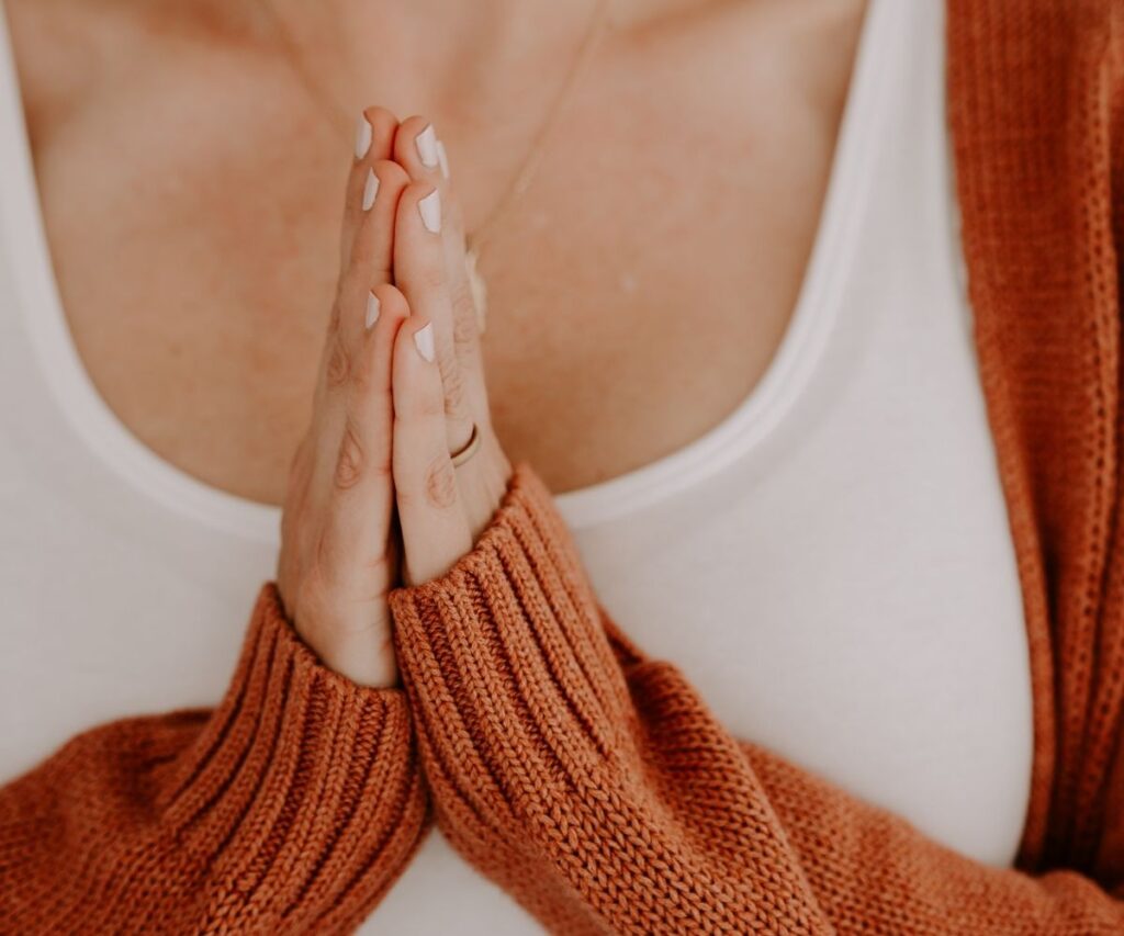Hands at heart center in prayer.