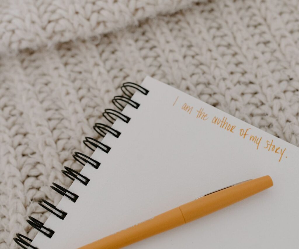 Affirmation written in orange on a notebook.