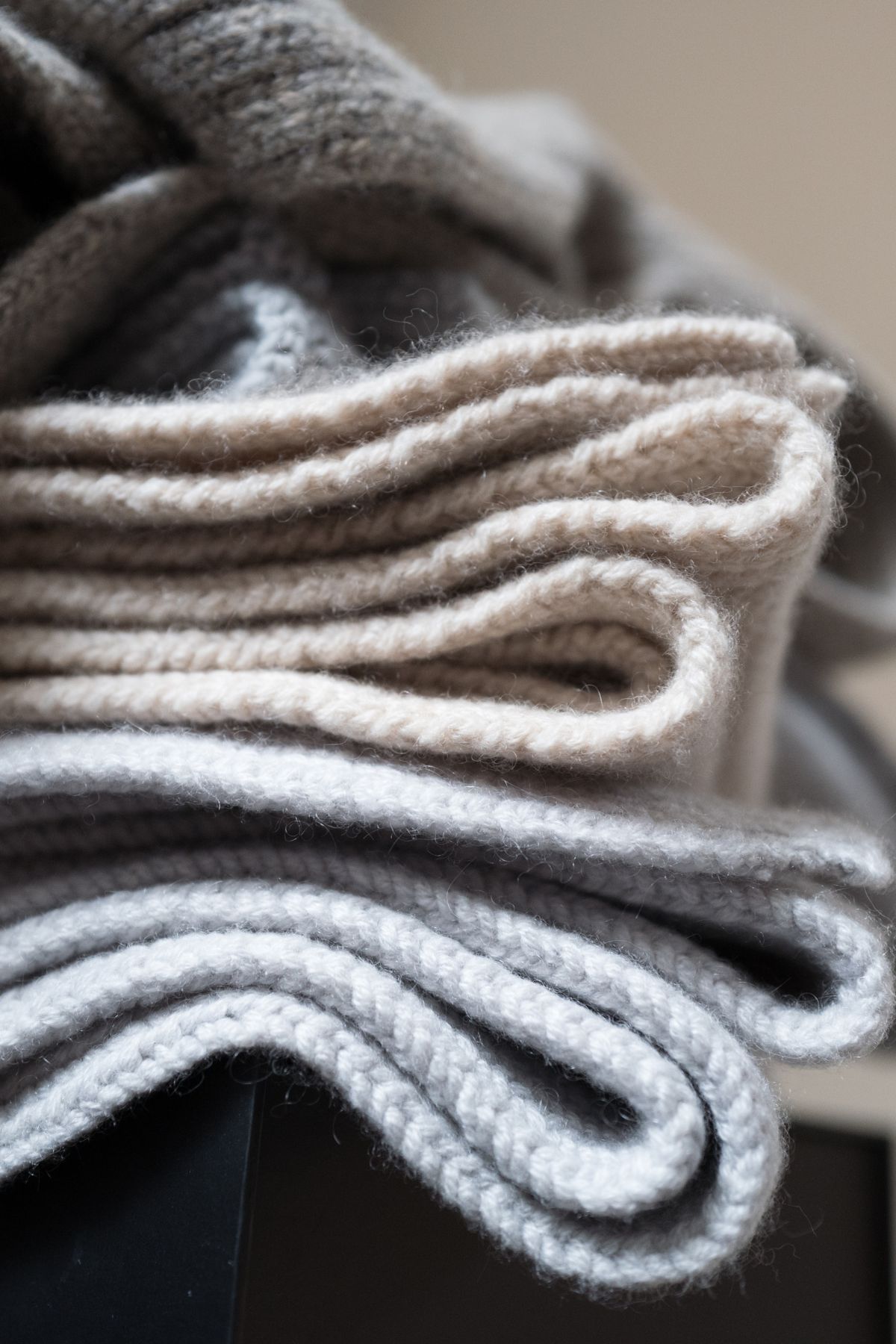 Stack of light colored fuzzy wool blankets.