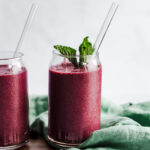 Two blueberry celery smoothies and a green towel.