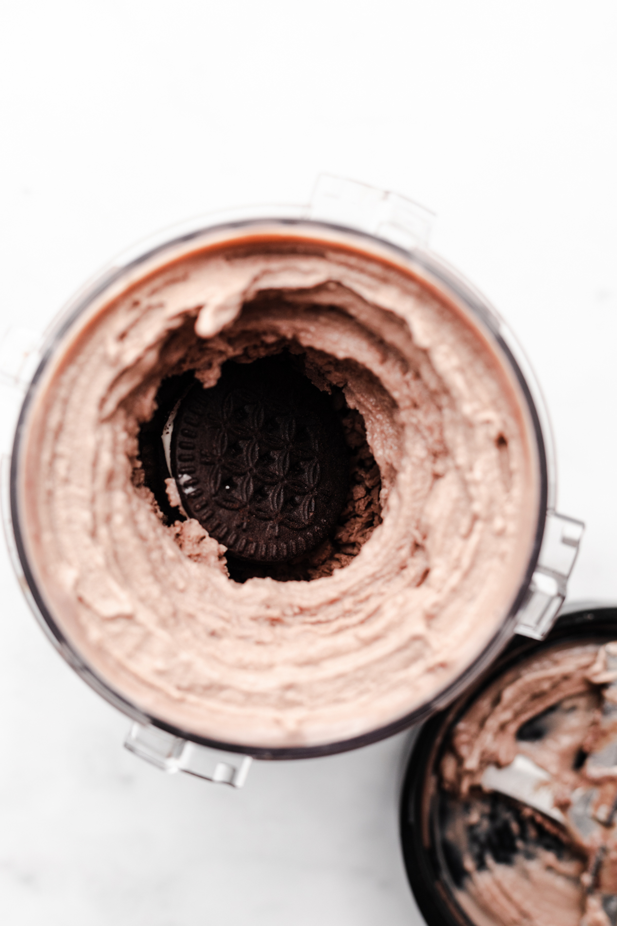 Chocolate Mint Creami Ice cream adding in the mix in. The oreo cookie is in the center of the ice cream well.