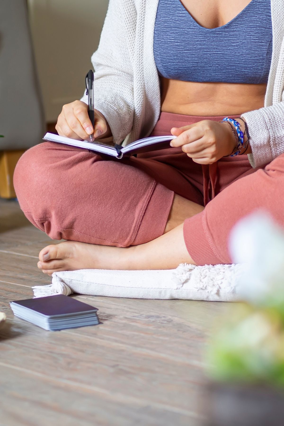 A woman in workout clothes journaling.